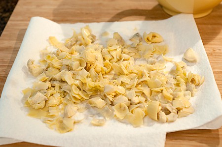 Draining chopped artichoke hearts