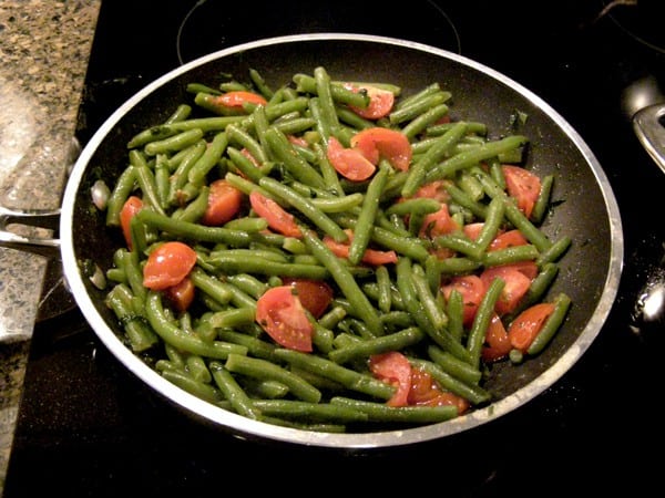 Green beans added to the skillet with tomatoes.