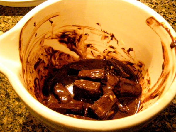 Partially melted chocolate and butter in a bowl.