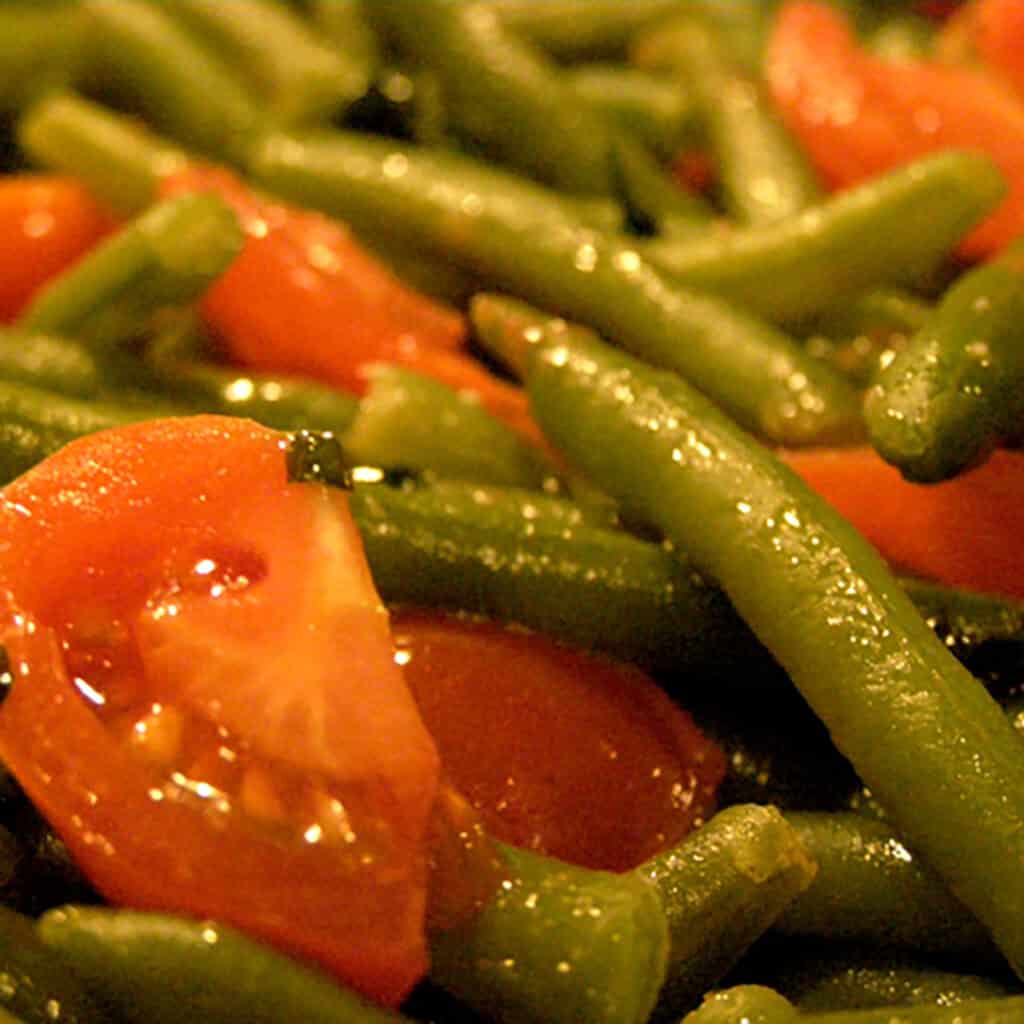 Close up view of finished green beans and cherry tomatoes.