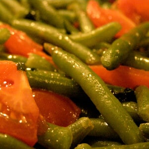 Green beans and cherry tomatoes on a serving dish.