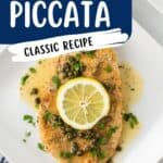 Breaded chicken piccata topped with capers, sauce, lemon slice, and parsley on a white plate.
