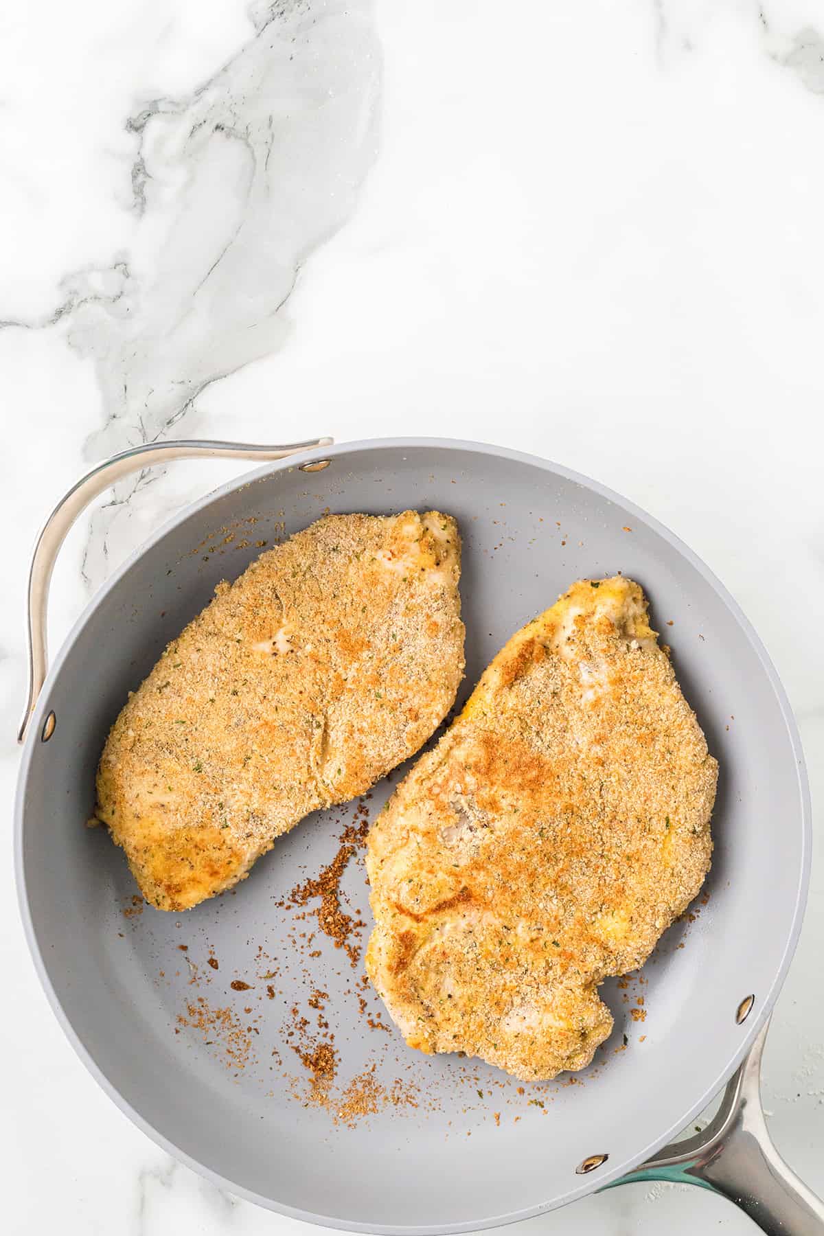 Browned chicken in a skillet.