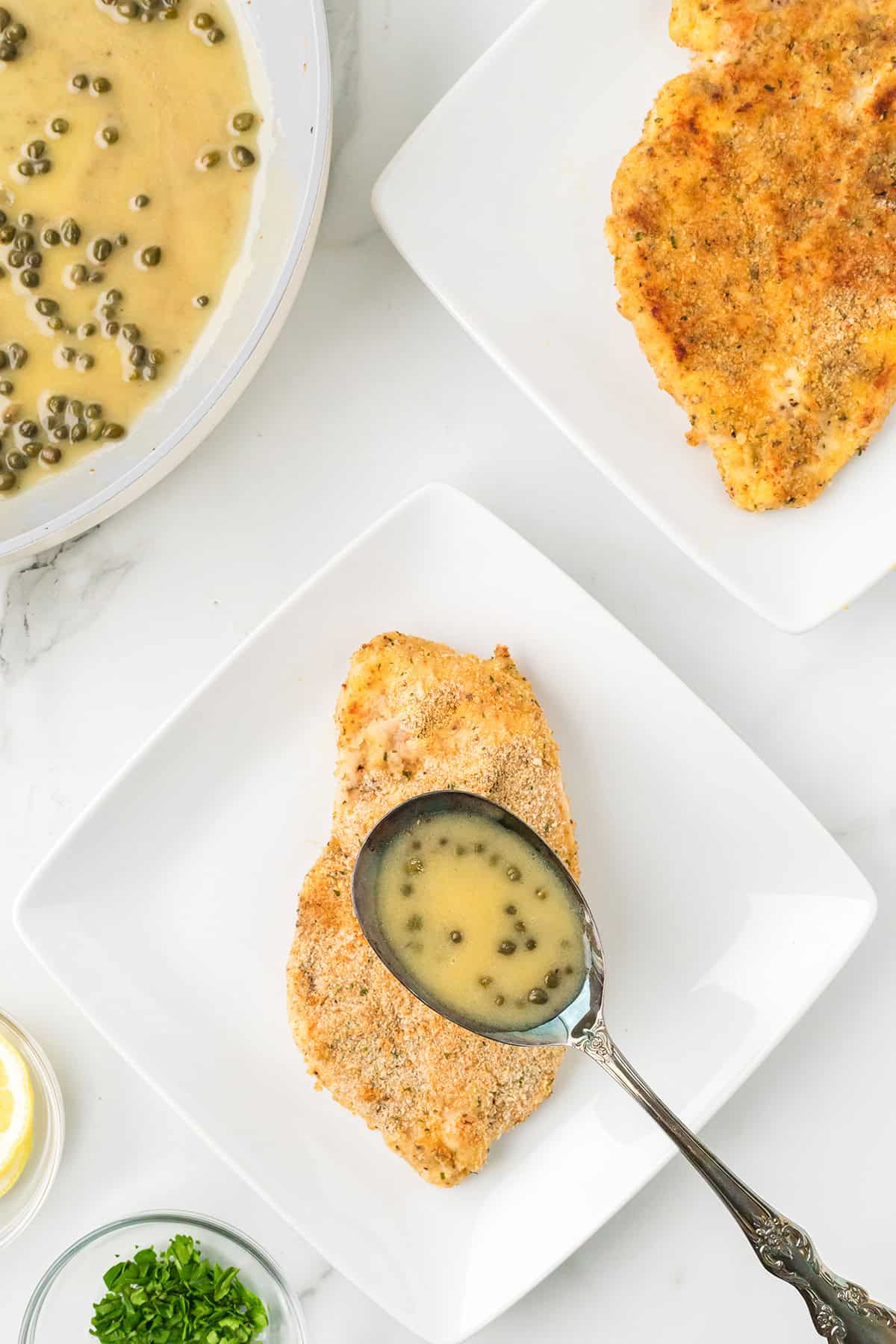 Adding sauce to chicken on a plate.