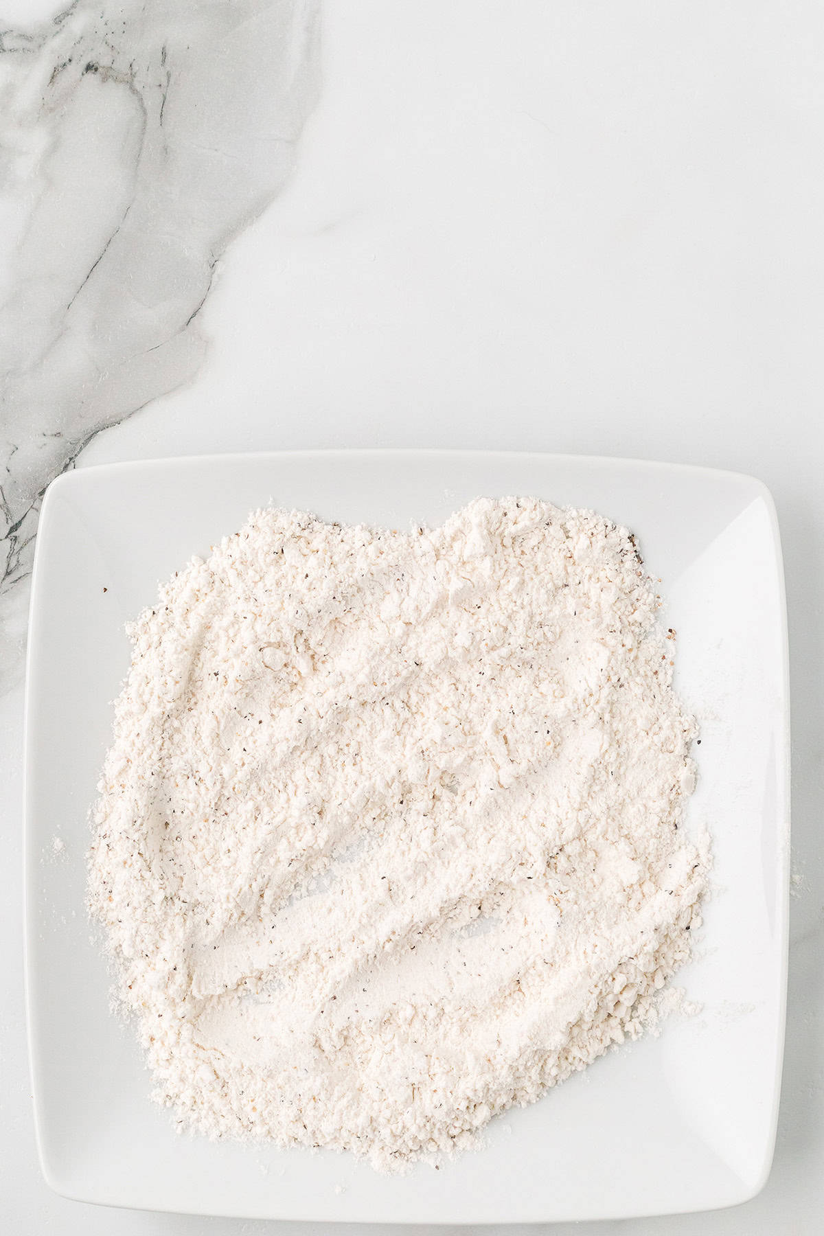 Seasoned flour on a plate.