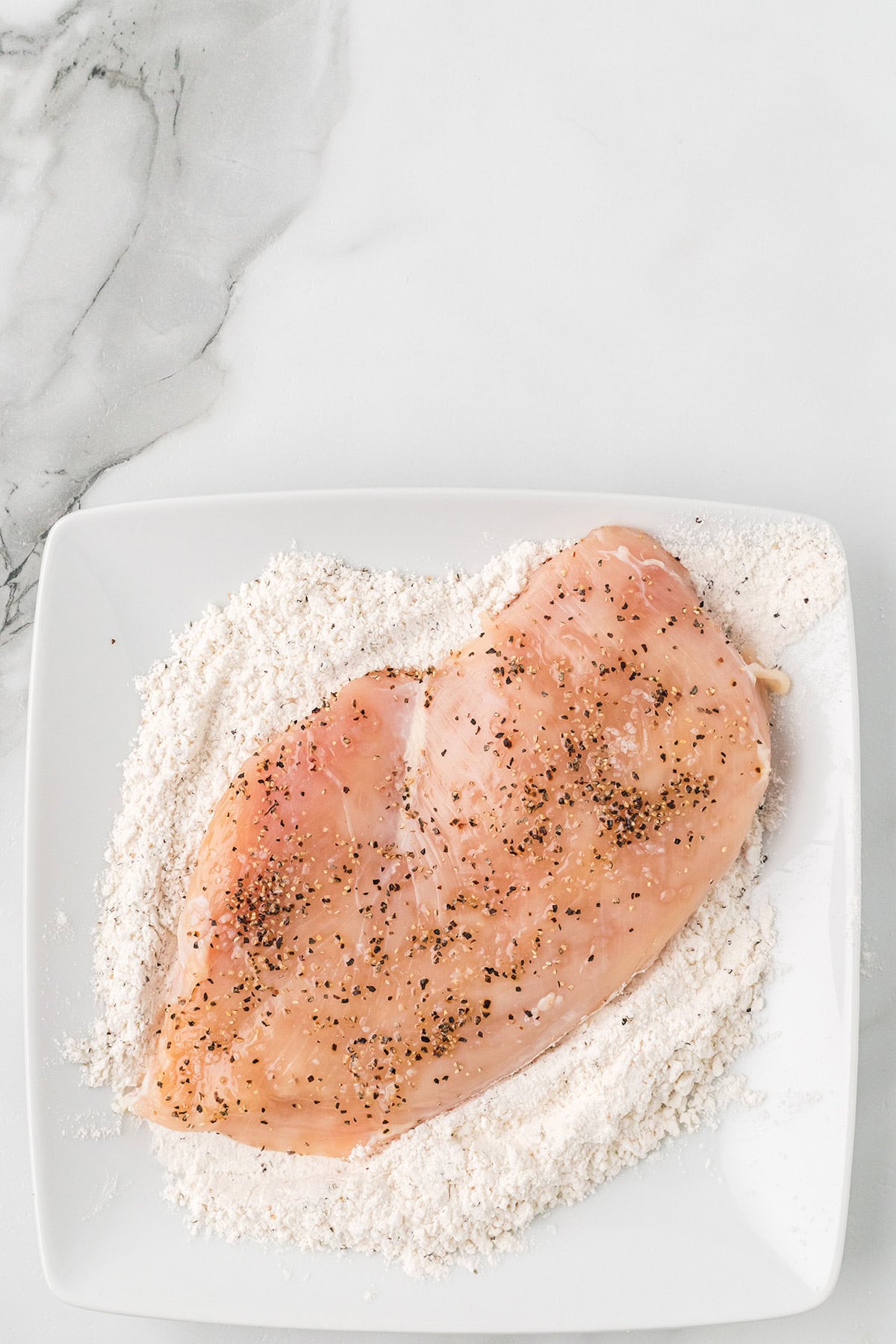 Seasoned chicken breast in flour.