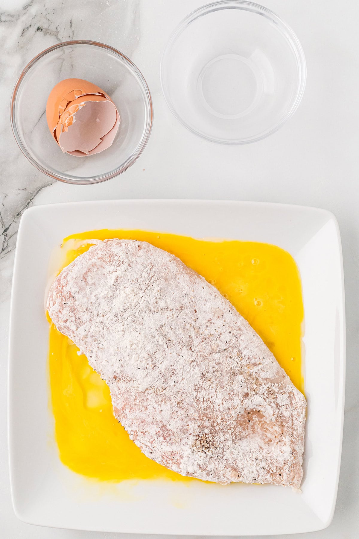 Floured chicken dipped in egg.