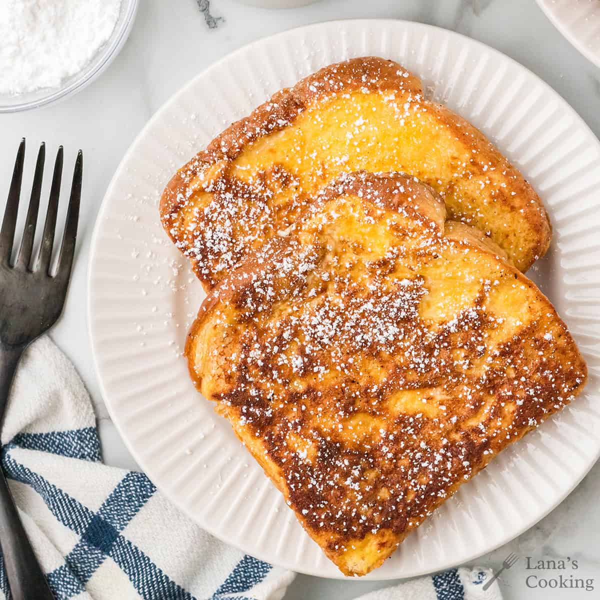 Two slices of French toast on a white plate.