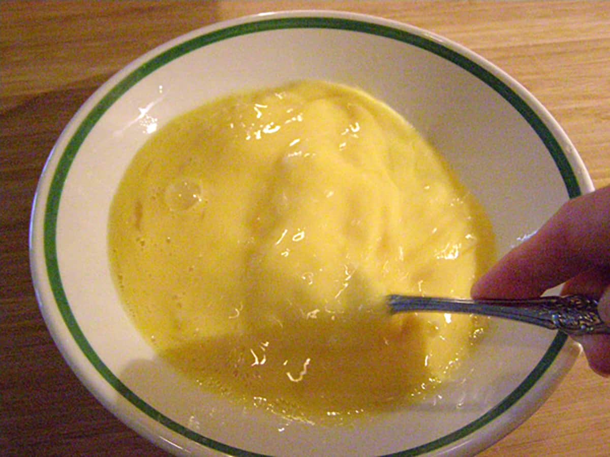 Beating eggs in a small bowl.
