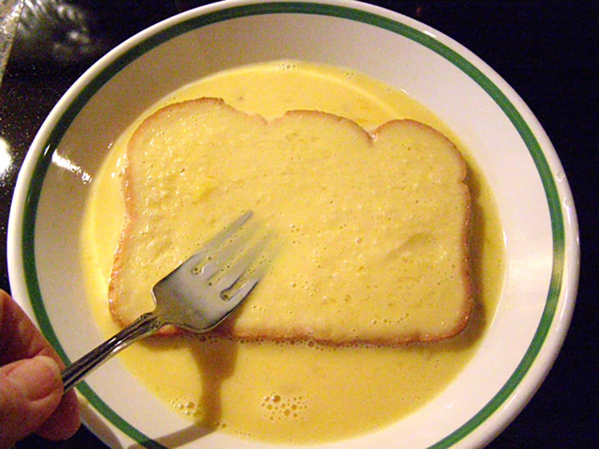 Dipping second side of bread into egg mixture.