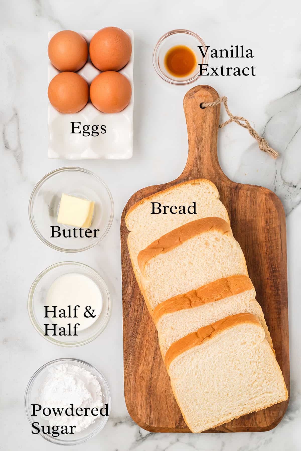 Iingredients for French toast on a marble background shot from above.
