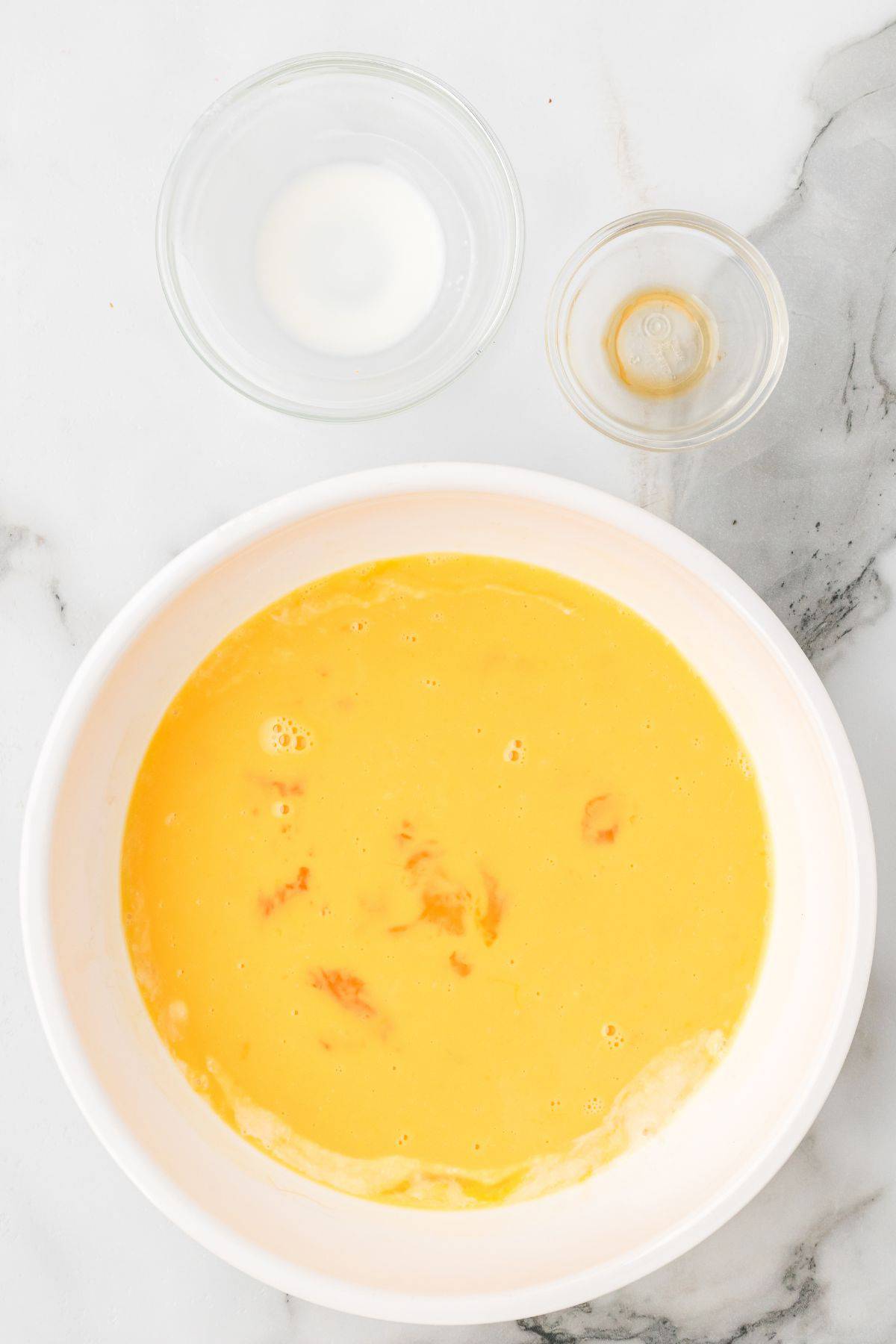 Beaten eggs in a mixing bowl.