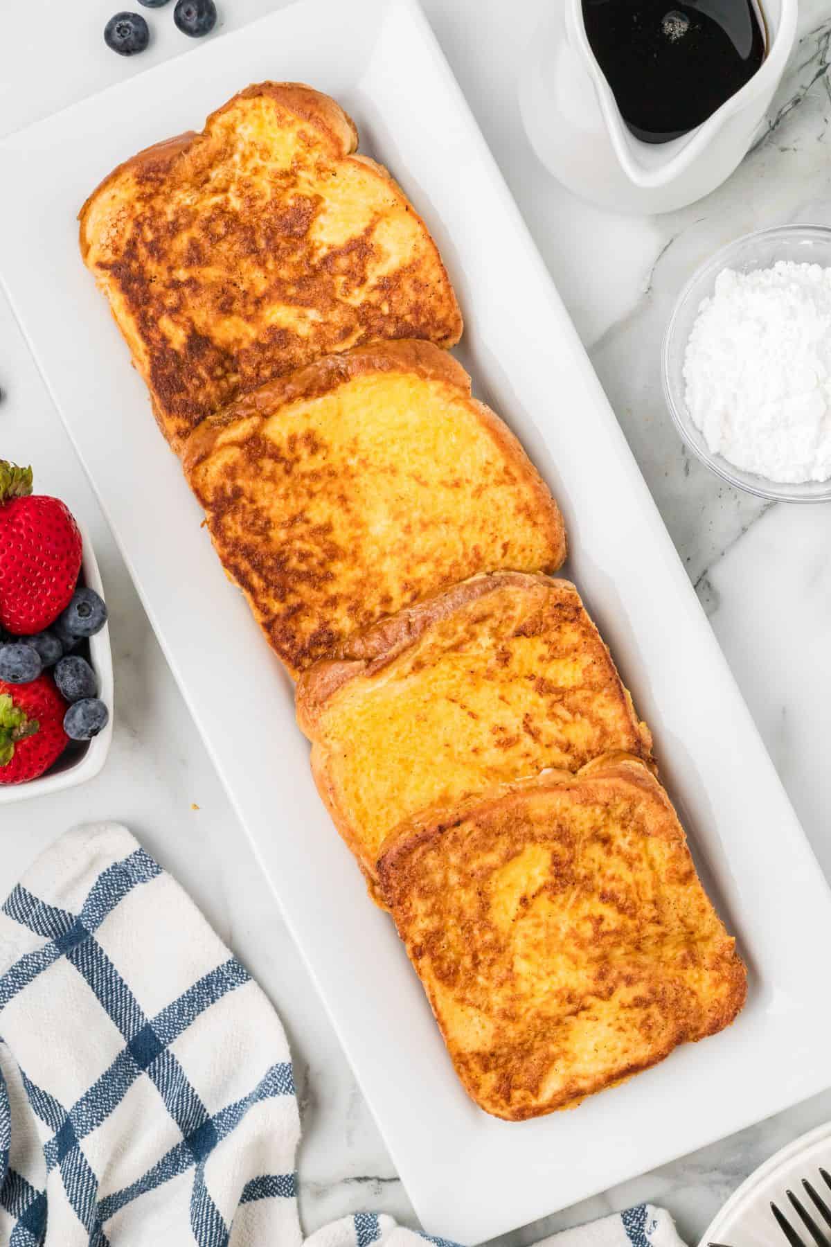 Slices of finished French toast on a white plate.