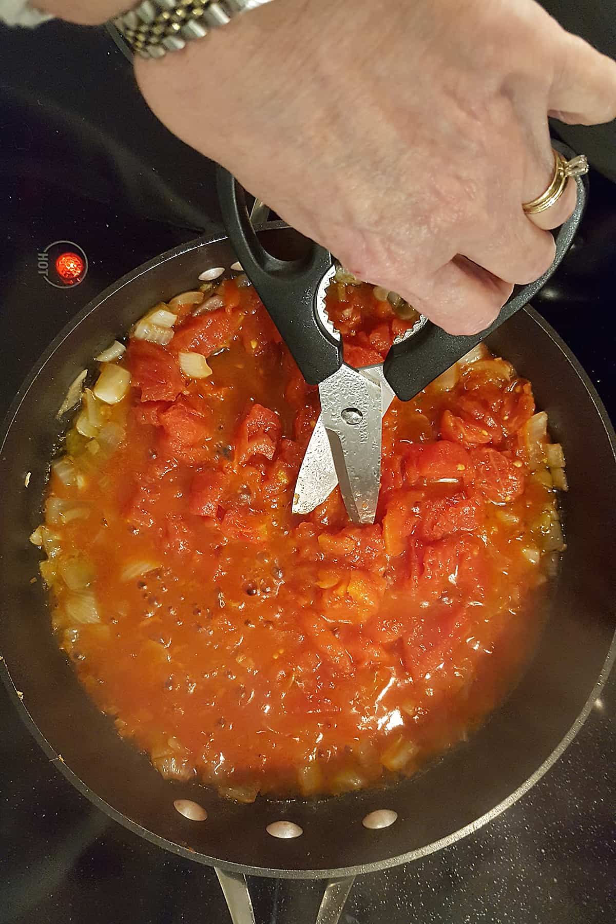 Dicing tomatoes with kitchen shears.