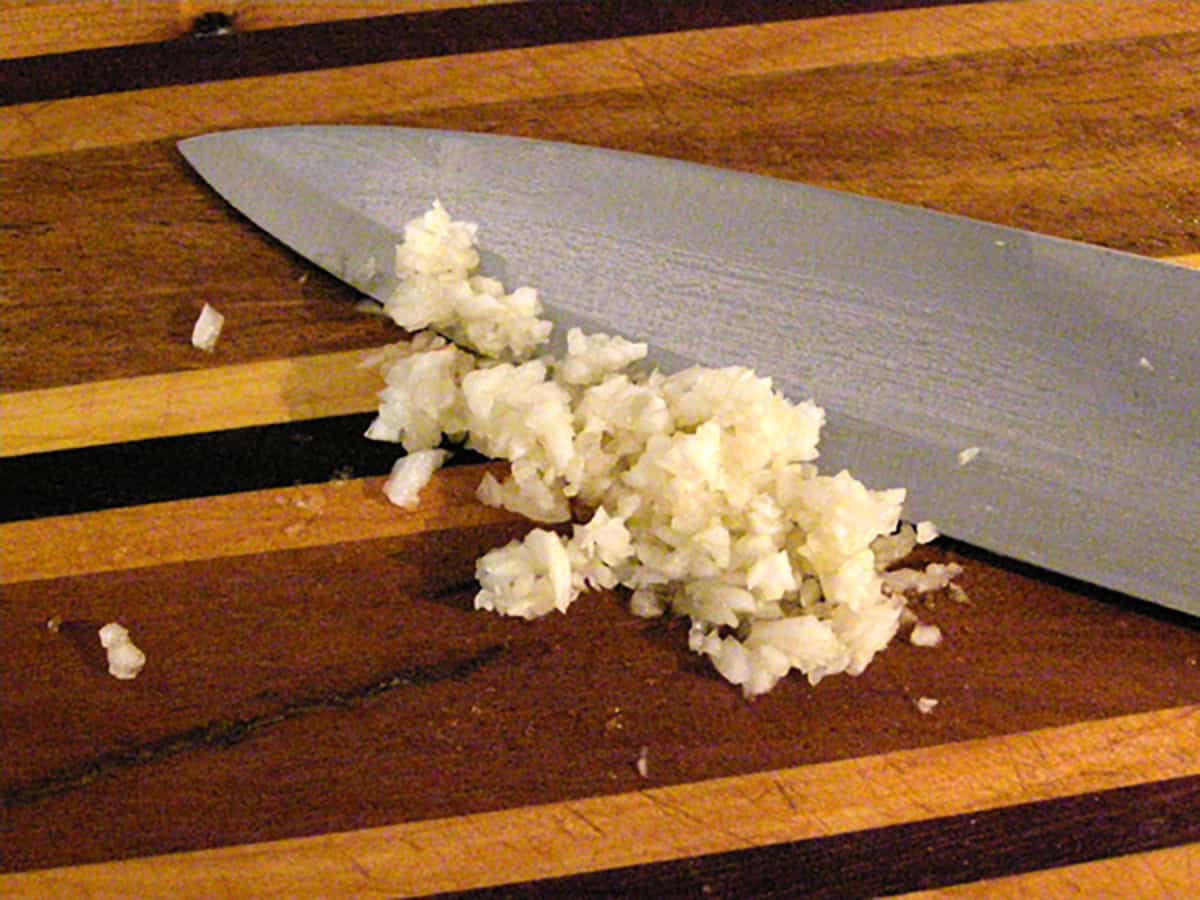 Finely chopped garlic on a cutting board.