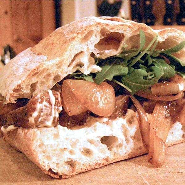 A luscious Steak Sandwich piled high with grilled onions, a spicy mustard mayo, and arugula on ciabatta bread. A meal all on its own. https://www.lanascooking.com/steak-sandwich/