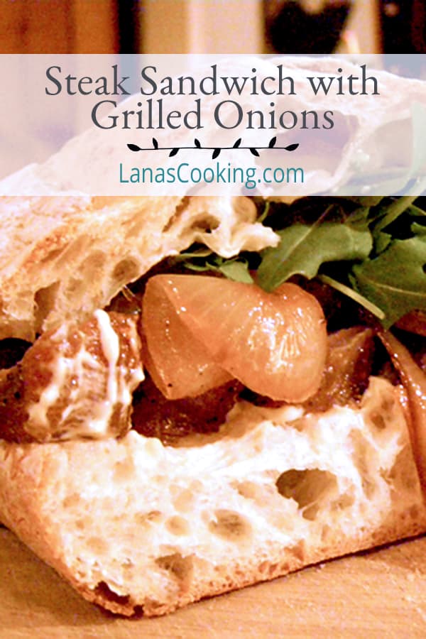 A luscious Steak Sandwich piled high with grilled onions, a spicy mustard mayo, and arugula on ciabatta bread. A meal all on its own. https://www.lanascooking.com/steak-sandwich/