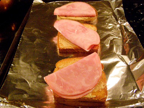 Sliced ham added on top of each piece of toasted bread.