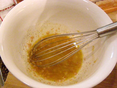 Mixing vinaigrette ingredients in a bowl.