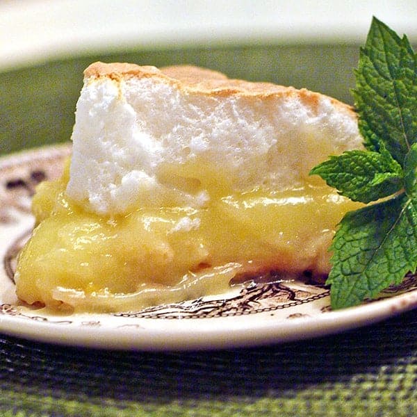 A slice of lemon meringue pie on a decorative serving plate.