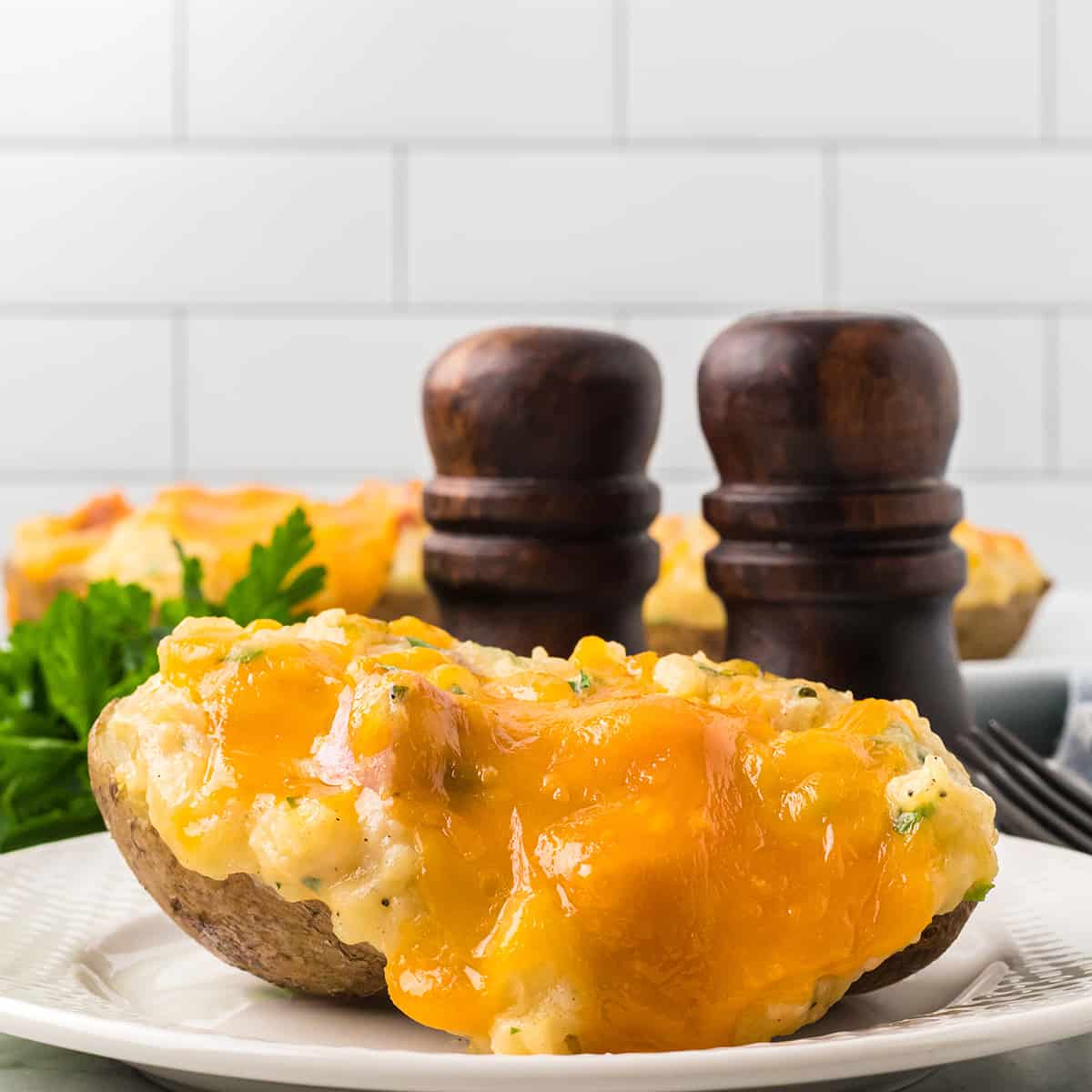 A serving of ham and cheese stuffed potatoes on a white plate.