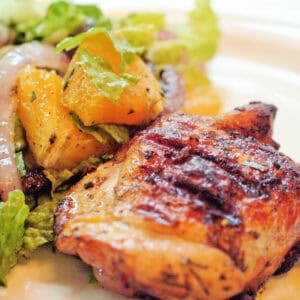 A serving of orange-rosemary chicken with salad on the side.