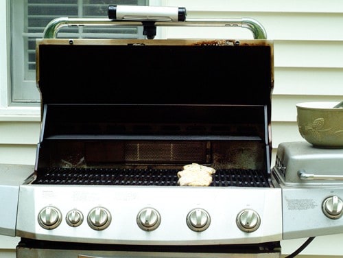 Grill with the top open and a cleaning cloth on the surface.