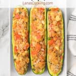 Three baked zucchini on a white plate.