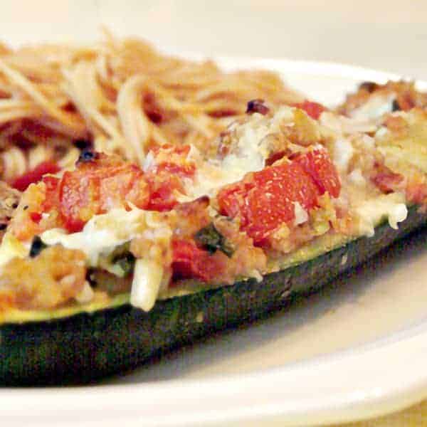 Stuffed Zucchini - fresh zucchini from the garden filled with a stuffing of onion, tomato, bread crumbs and parmesan cheese. https://www.lanascooking.com/stuffed-zucchini/