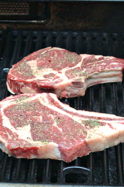 Steaks cooking on a gas grill.