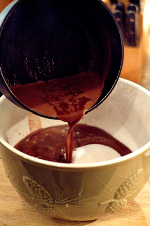 Pouring cocoa mixture into dry ingredients.