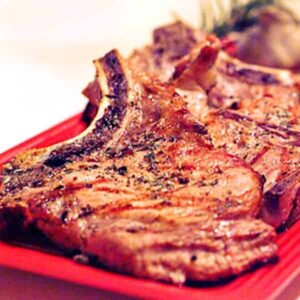 Grilled Pork Chops - pork chops seasoned with a fresh rosemary and garlic rub and cooked on an outdoor grill. Serve with your favorite green vegetables. https://www.lanascooking.com/grilled-pork-chops
