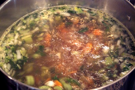 Veggies and stock boiling in a soup pot.