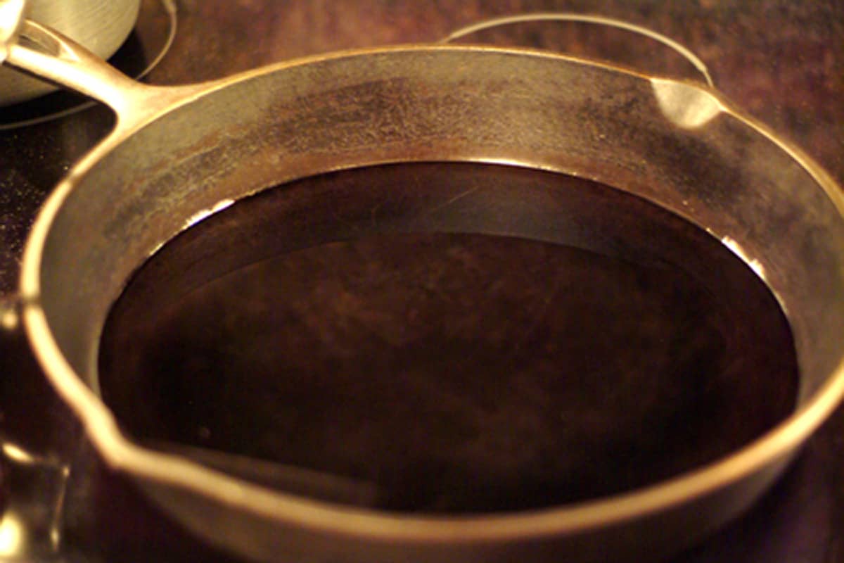 A cast iron skillet with oil in the bottom.