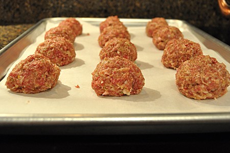 Meatballs formed and placed on a baking sheet.