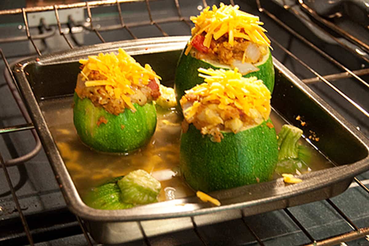 Additional cheese added to tops of stuffed zucchini.