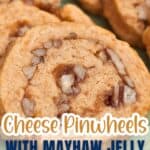 Close-up of cheese pinwheel cookies with bits of nuts, labeled as made with mayhaw jelly. Text overlay reads “Cheese Pinwheels with Mayhaw Jelly.”.