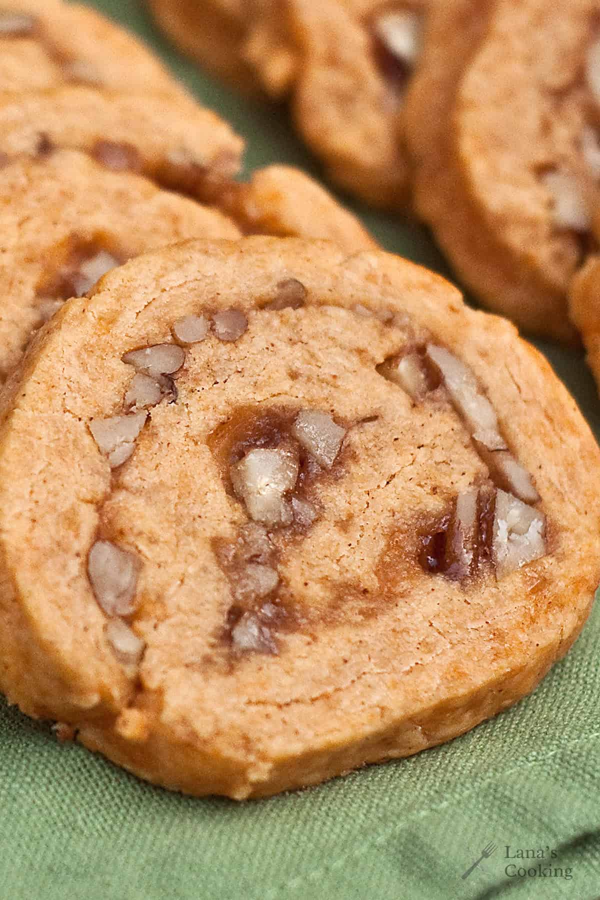 A close-up of cheese pinwheels with Mayhaw jelly arranged on a green fabric surface.