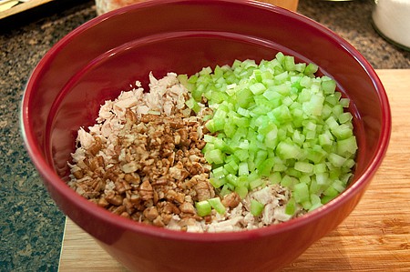 Chicken, pecans, and celery in a mixing bowl.