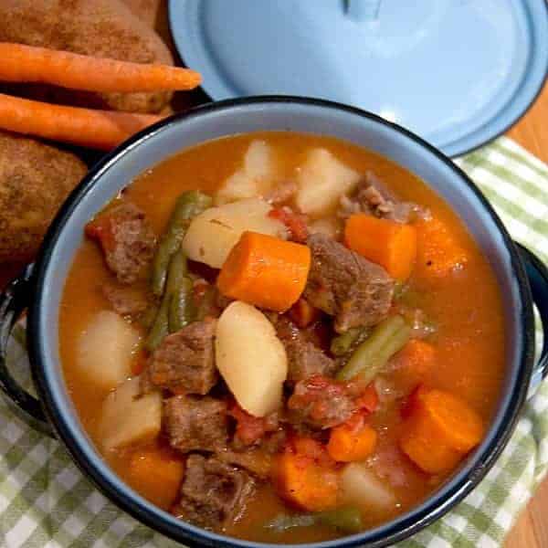 Pressure Cooker Beef Stew - a hearty beef stew with potatoes, carrots, green beans, and tomatoes can be on the table in minutes when you use a pressure cooker. https://www.lanascooking.com/beef-stew-in-the-pressure-cooker/