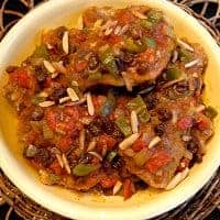 Chicken Country Captain is a true old South classic. Chicken, onions, garlic, peppers and curry powder with raisins and toasted almonds. https://www.lanascooking.com/chicken-country-captain/