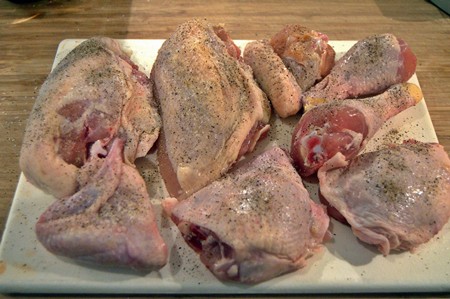 Chicken pieces coated with salt and pepper.