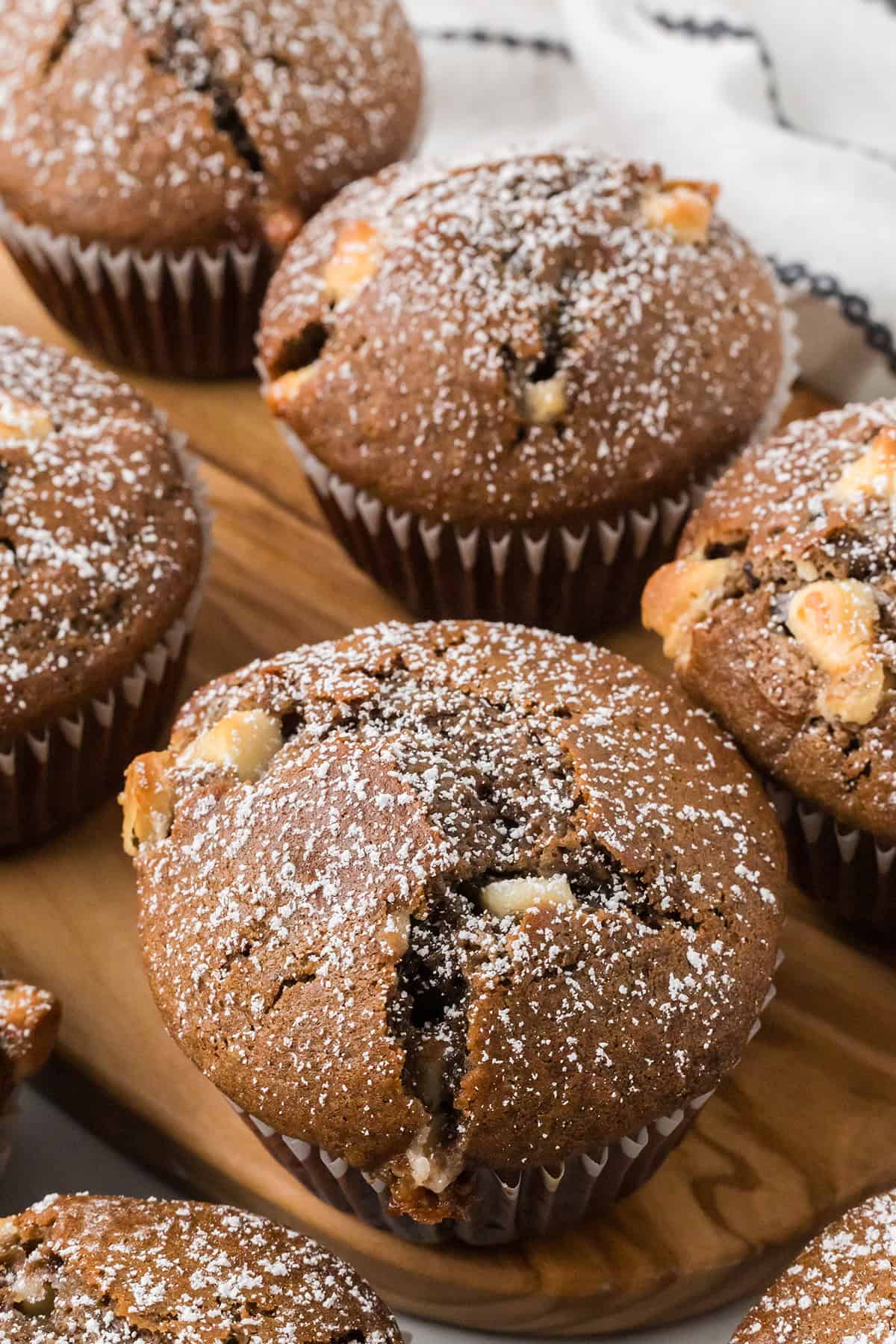 Several muffins arranged on a wooden board.
