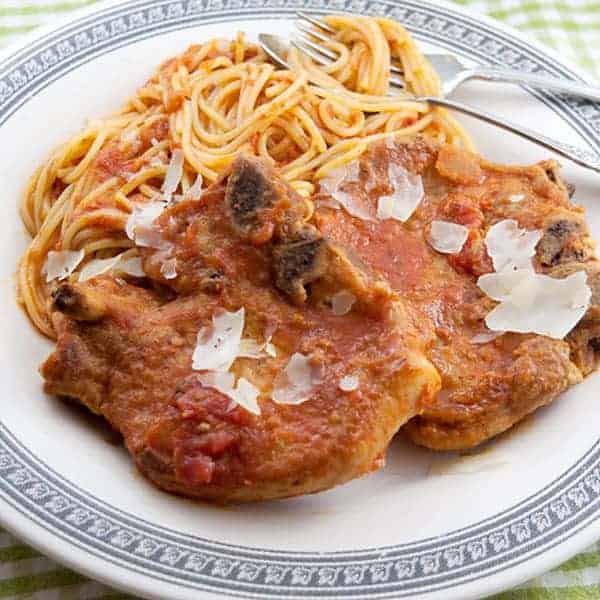 Pork chops and spaghetti on a serving plate.