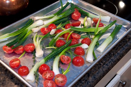 Baking sheet of onions and tomatoes ready for the oven.