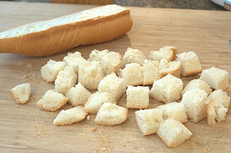 Bread for Homemade Croutons Cubed bread on a cutting board.