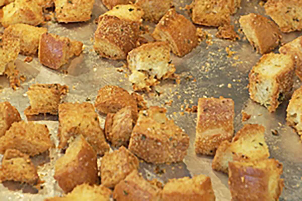 Crunchy, golden-brown croutons scattered on a baking sheet.