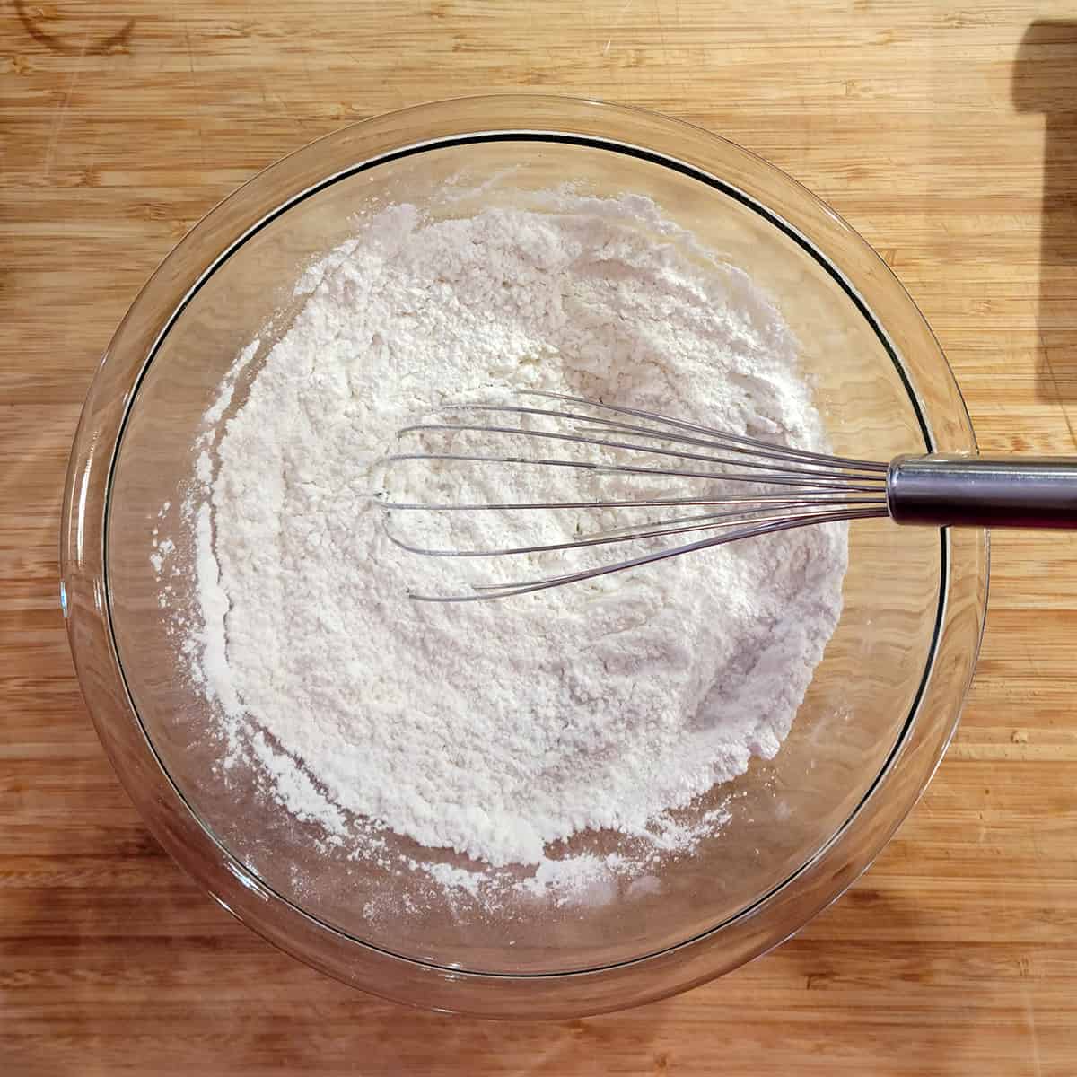 Flour, baking powder, sugar, and salt in a mixing bowl.