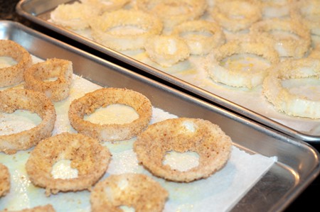 Prepared onion rings on a prepared baking sheet lined with parchment paper