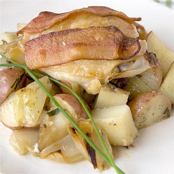 Bacon Roasted Chicken Thighs - Chicken thighs topped with bacon and roasted atop a bed of potatoes and onions. https://www.lanascooking.com/bacon-roasted-chicken-thighs/
